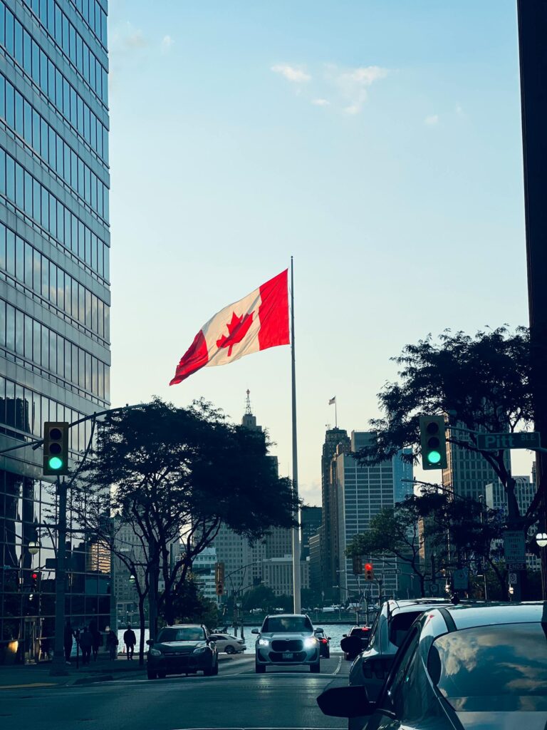 canadian flag blowing in the wind Photo by Mansor Abbasi: https://www.pexels.com/photo/windsor-cityscape-with-canadian-flag-at-twilight-33262693/